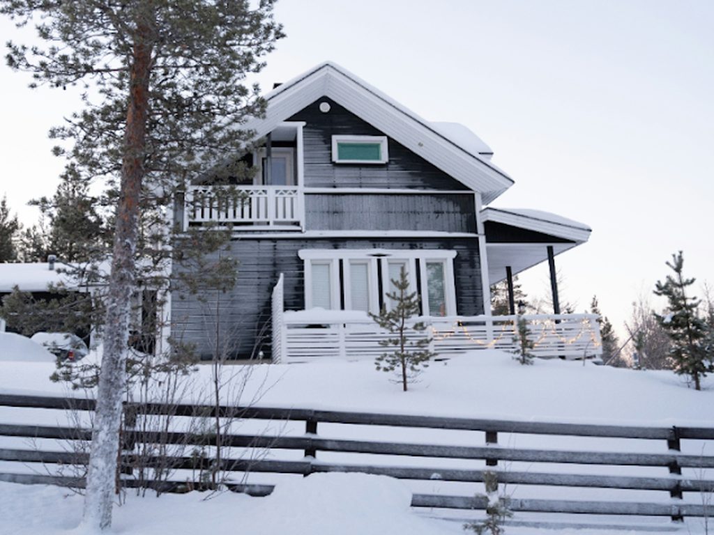 Norsk hytte i vinterlandskap med måkt inngangsparti